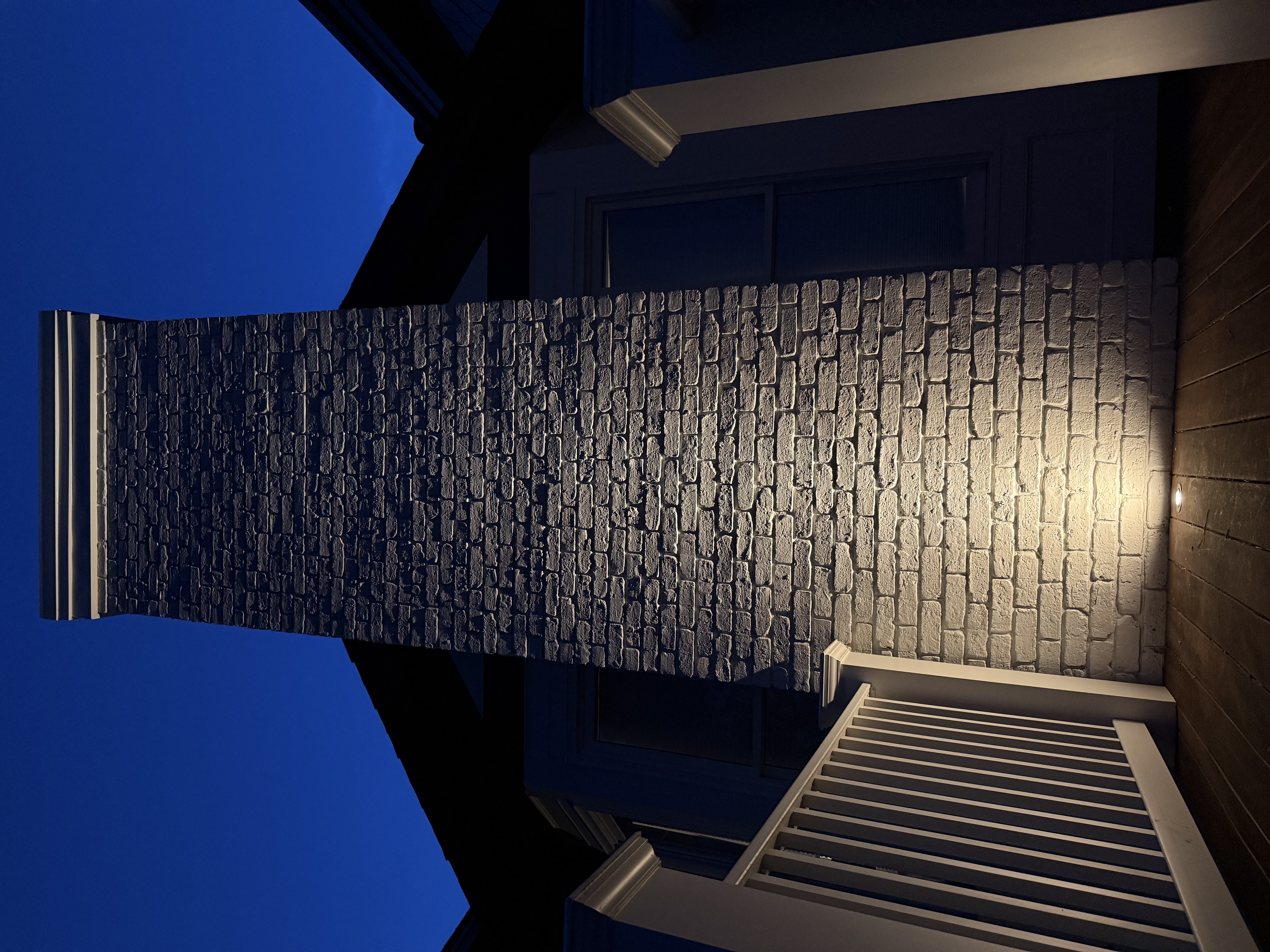 White brick chimney well light uplighting detail
