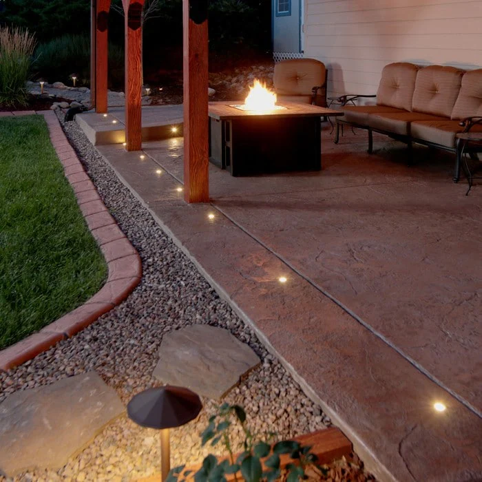 Well lights illuminating a patio outdoor living area